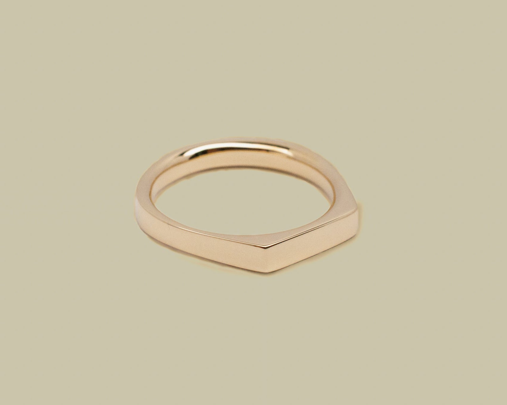 Gold ring on a beige background