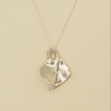 Silver necklace with a unique pendant on a beige background