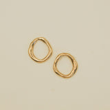 Gold hoop earrings on a beige background