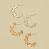 Set of gold and silver scalloped hoop earrings on a beige background. sand cast by hand
